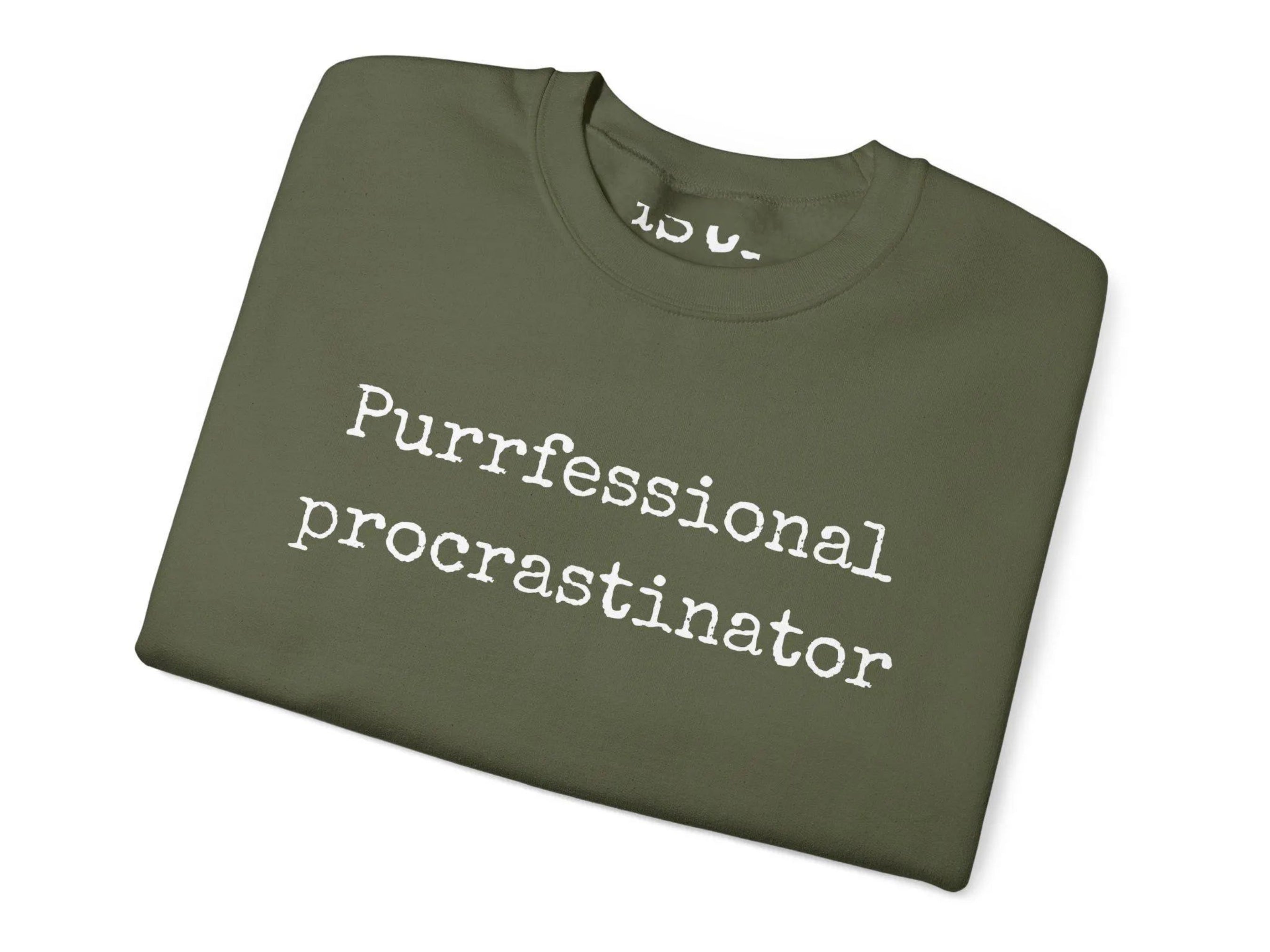 Folded green t-shirt with 'Purrfessional procrastinator' text on a white background