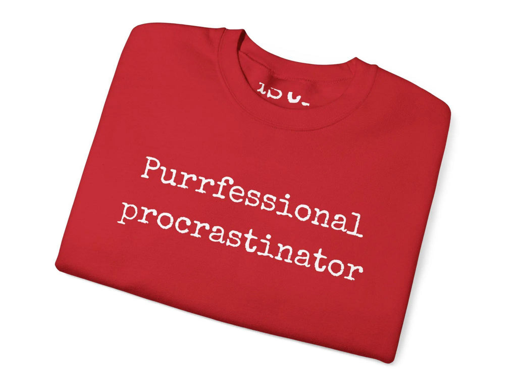 Folded red t-shirt with 'Purrfessional procrastinator' text on a white background