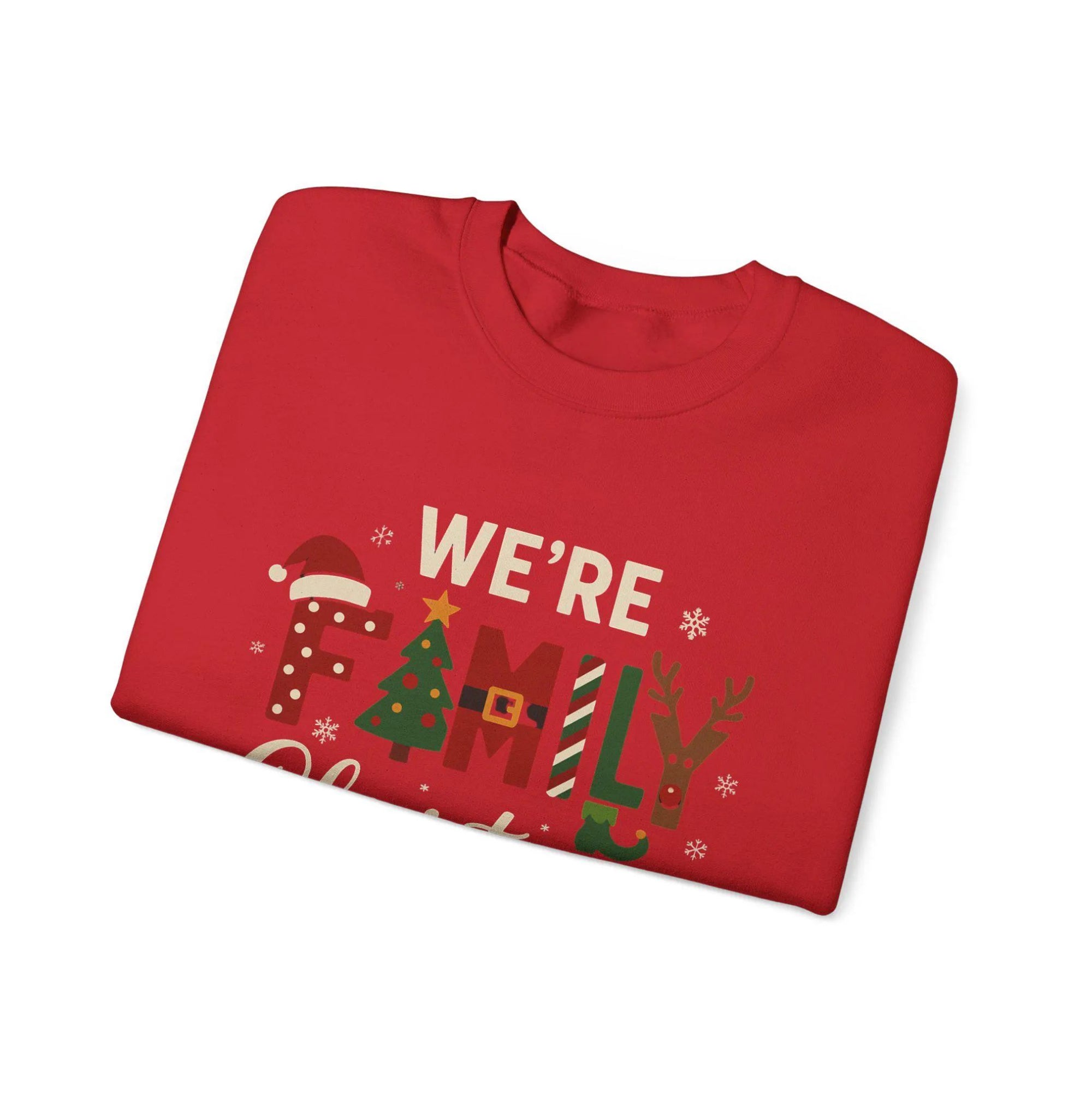Folded red Christmas-themed t-shirt with 'We're Family' text on a white background