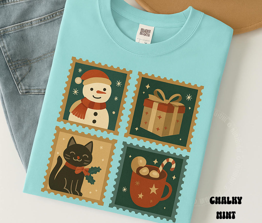Chalky mint shirt with retro Christmas stamps showing a snowman wrapped gift black cat and hot cocoa mug