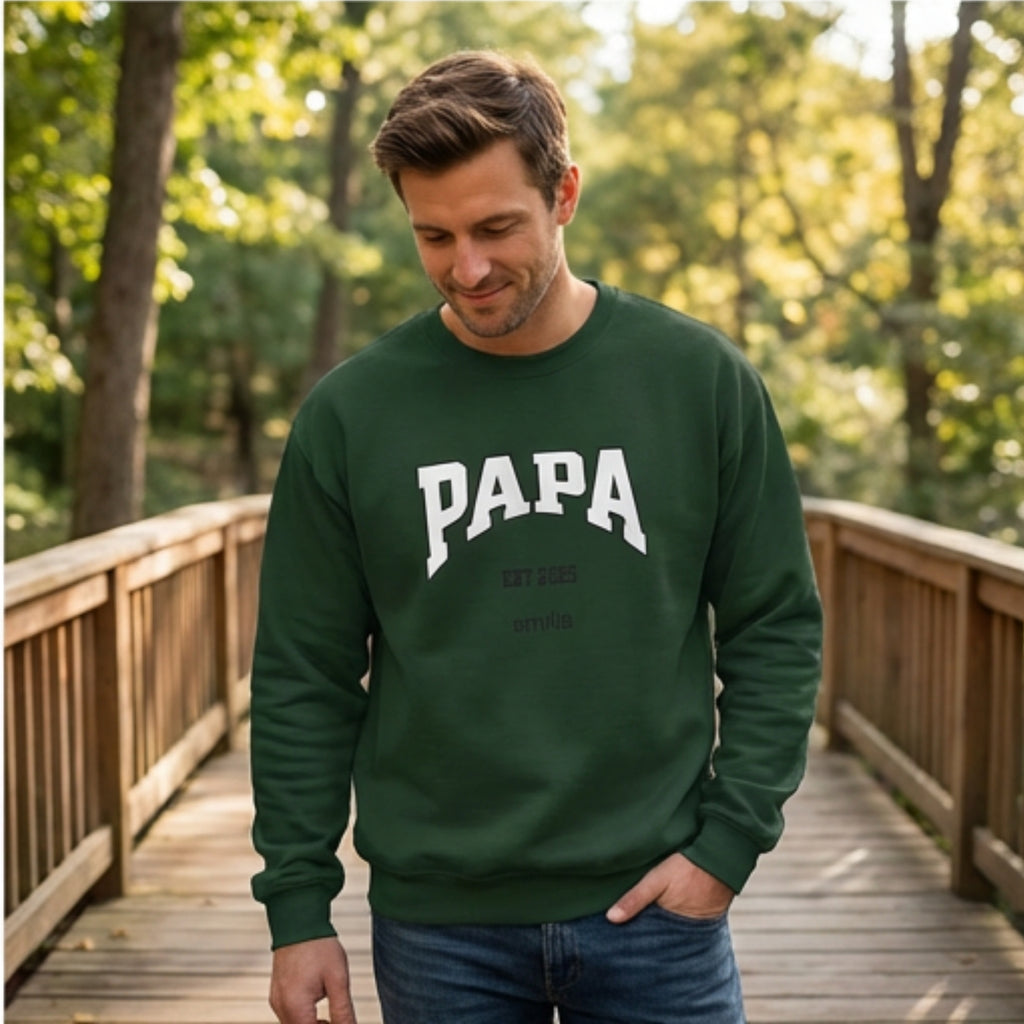 Man wearing forest green custom Papa Est 2025 crewneck sweatshirt with kids names. A perfect new dad gift.