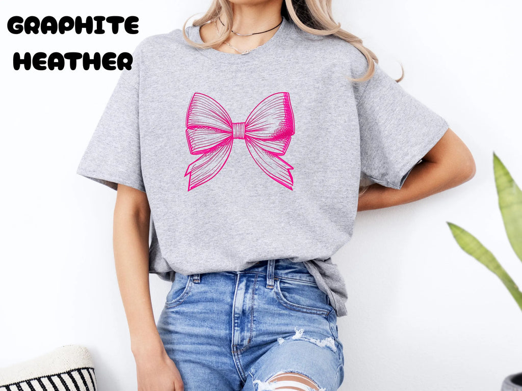 Person wearing a gray t-shirt with a pink bow design on a white background