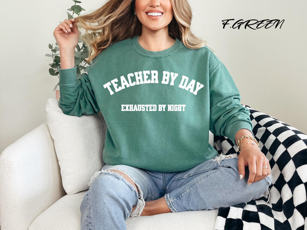 Person wearing a green sweatshirt with text, sitting on a couch.