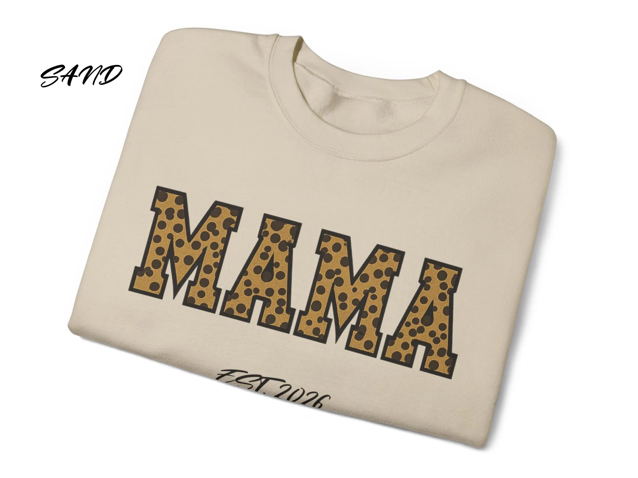 Folded beige sweatshirt with 'MAMA' in leopard print on a white background