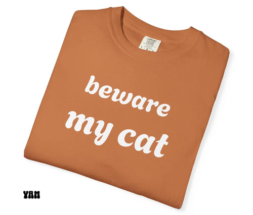 Brown t-shirt with 'beware my cat' text on a white background