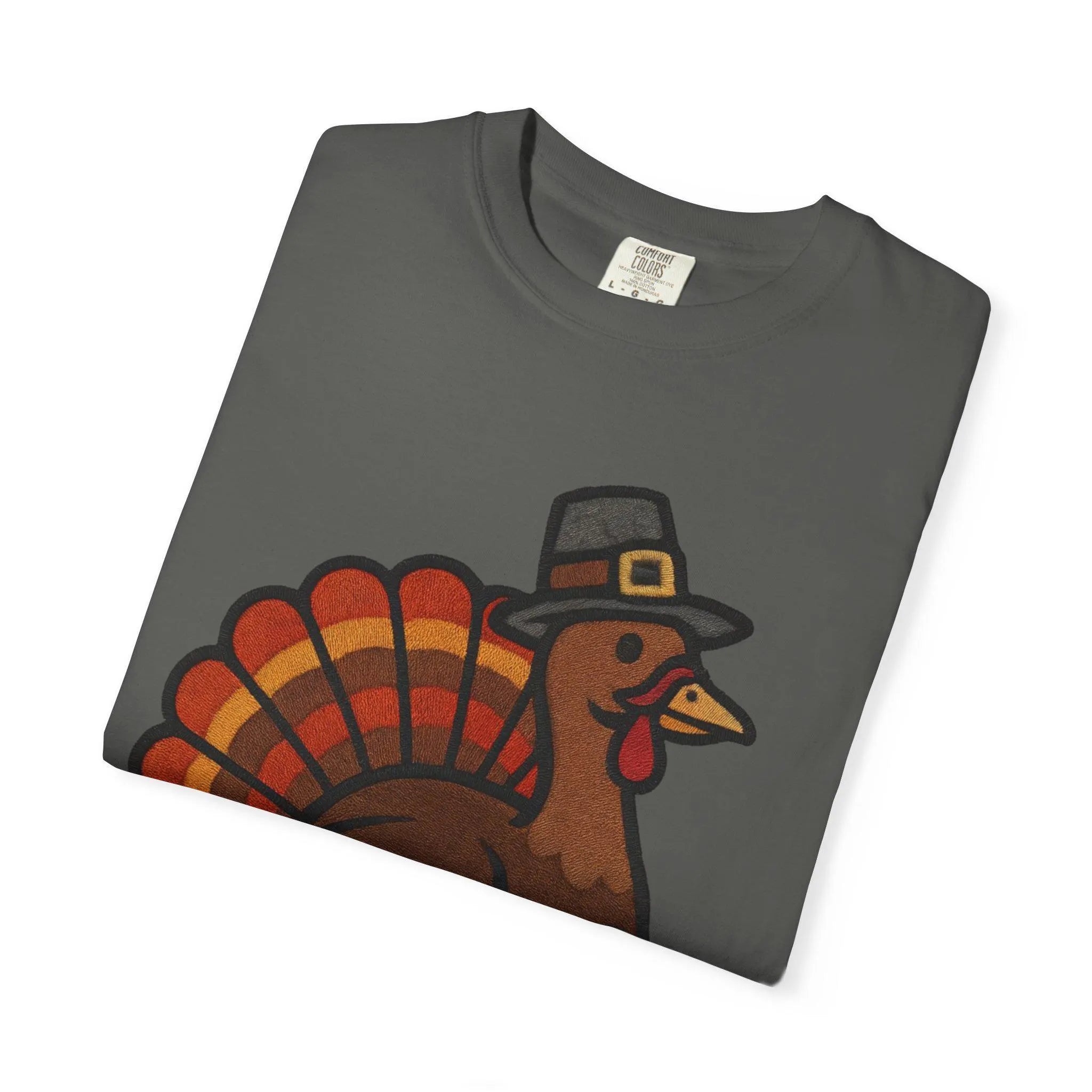 Folded gray t-shirt with a turkey graphic wearing a pilgrim hat on a white background