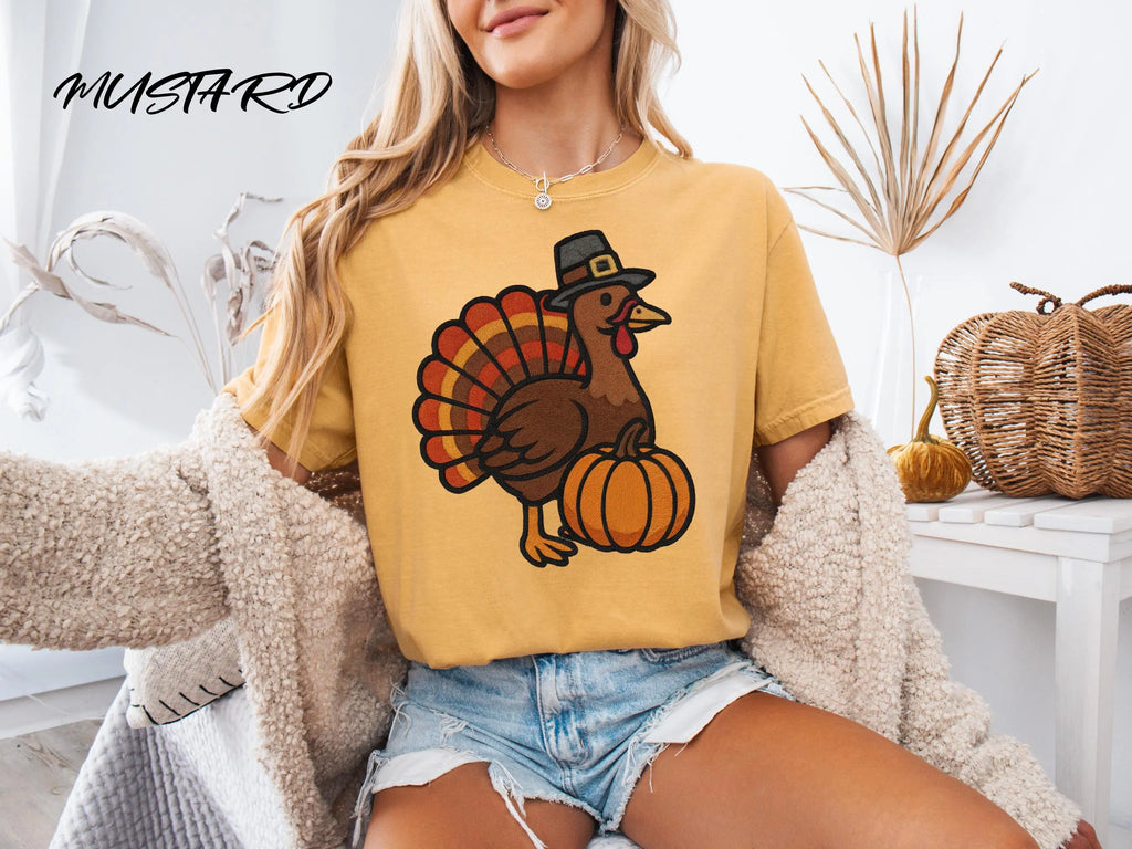 Person wearing a mustard yellow t-shirt with a turkey graphic and 'Mustard' branding.