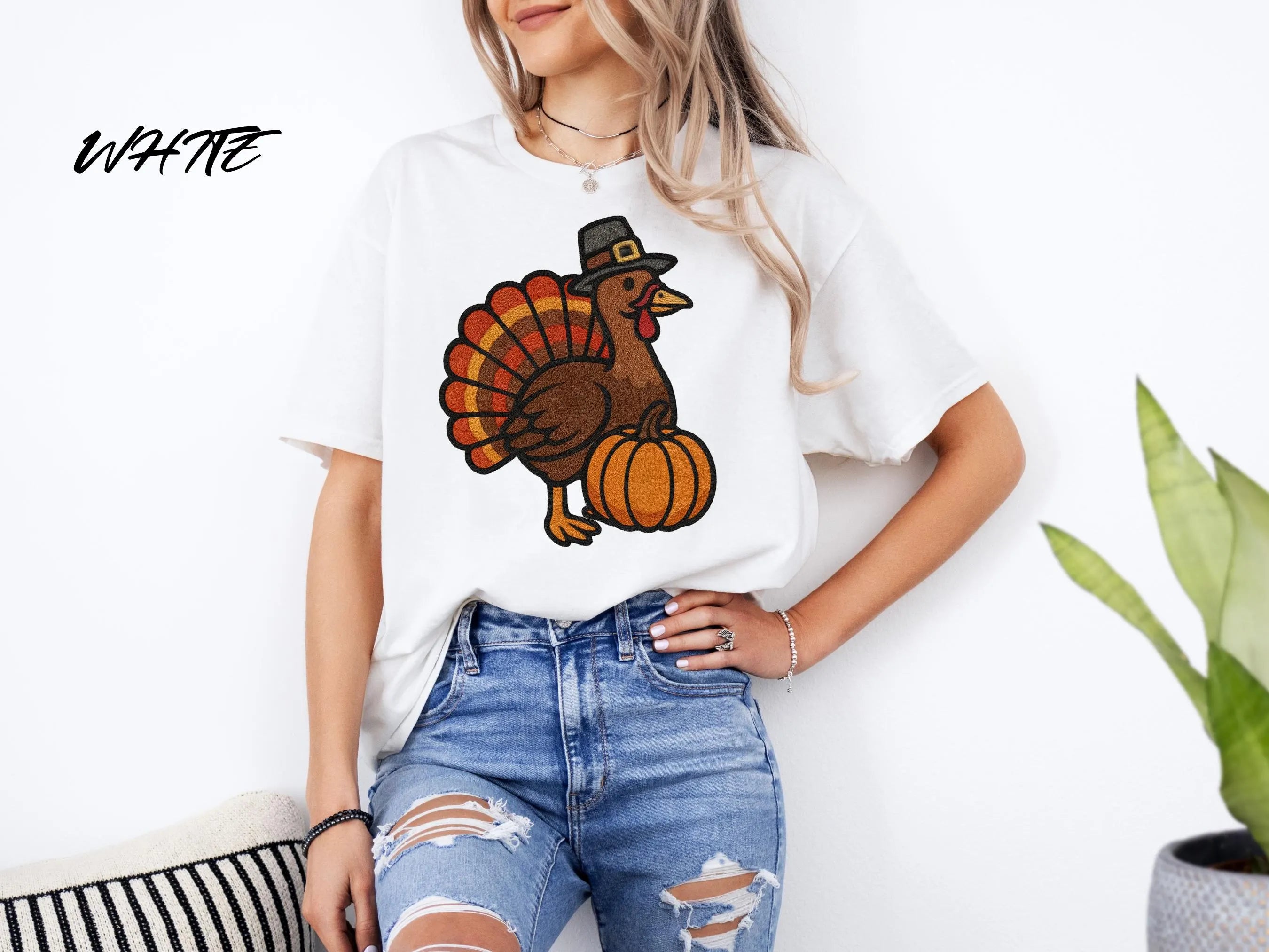 Person wearing a white t-shirt with a turkey graphic and blue jeans indoors.