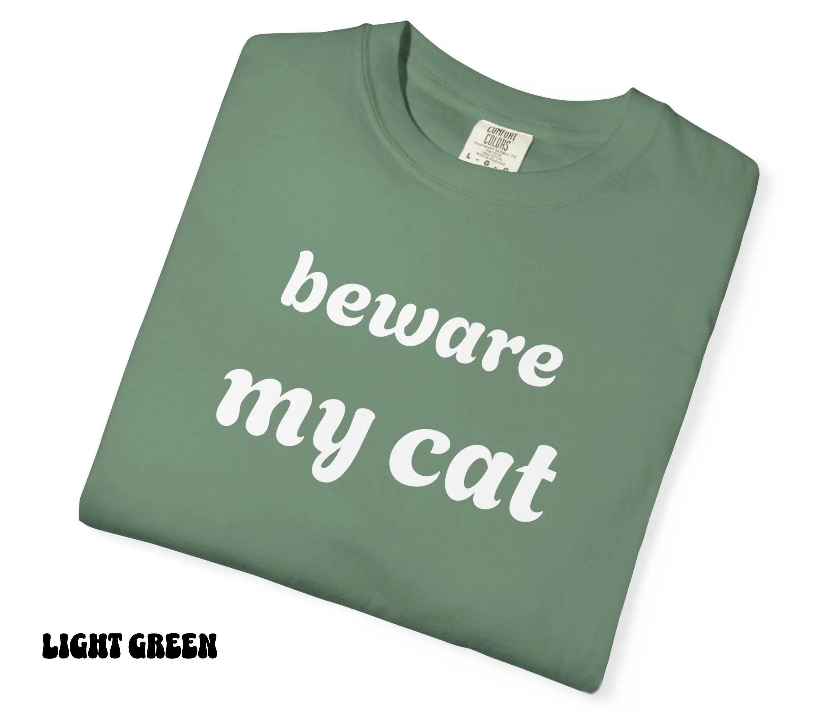 Light green t-shirt with 'beware my cat' text on a white background